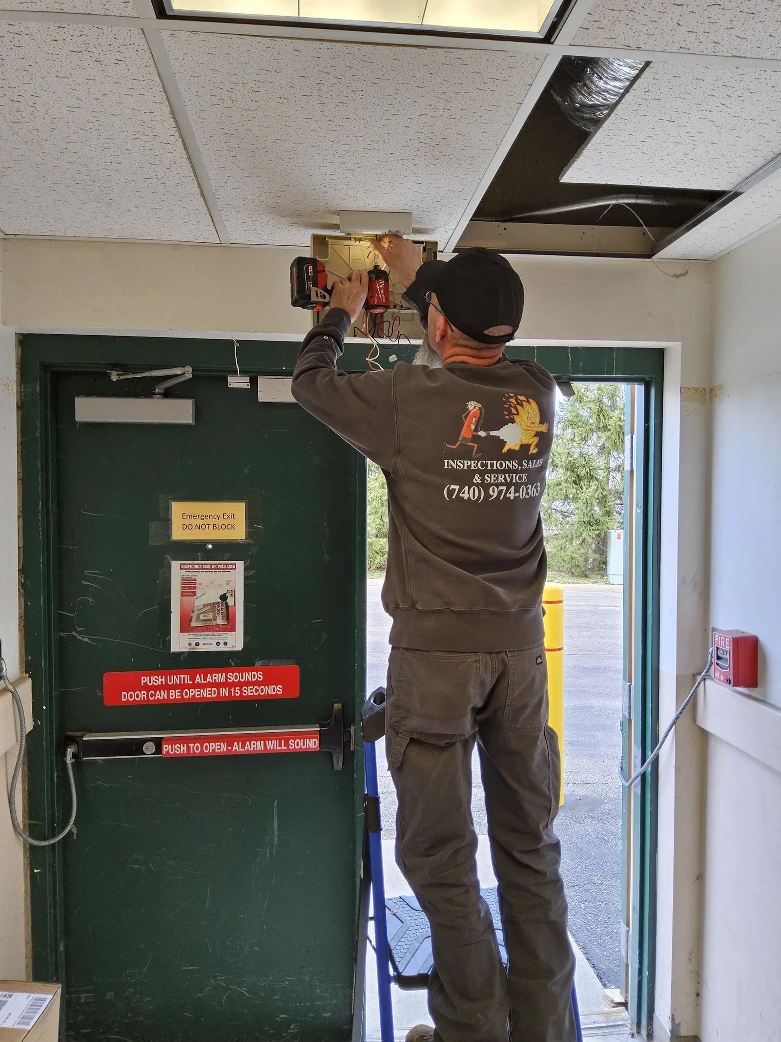 Illuminated exit sign inspected by a Fairfield Fire Protection technician